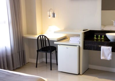 Ambiente geral do quarto Master do Hotel São Mateus mostrando o local para trabalho